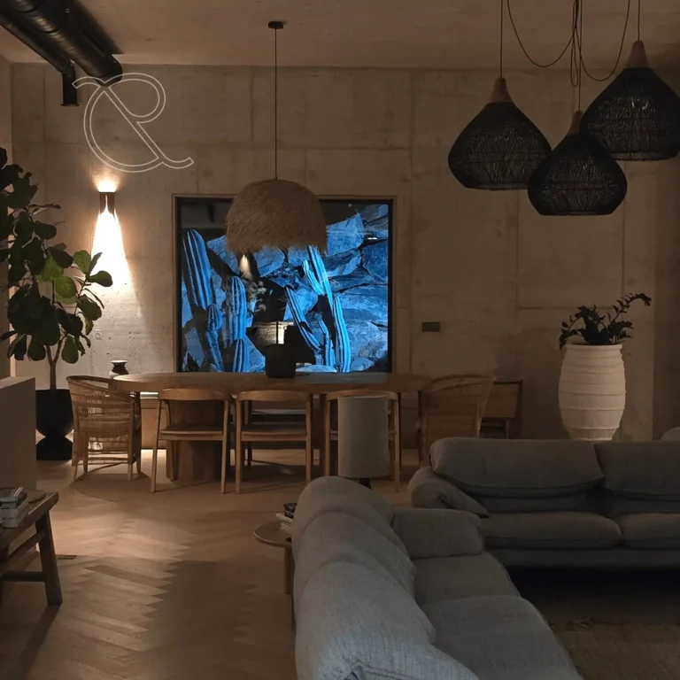 Salle à manger spacieuse et lumineuse, donnant sur une partie du jardin paysager à travers une grande fenêtre, créant une scène digne d’un tableau, propre aux propriétés proposées par notre agence immobilière à Porto-Vecchio.