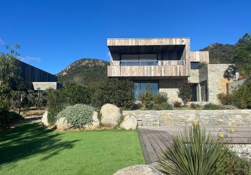Villa avec vue mer en Corse-du-Sud, architecture contemporaine entourée de nature, offrant un cadre lumineux et une ouverture vers la Méditerranée.
